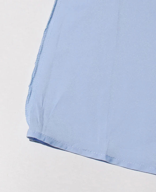 Close-up of a light blue fabric corner on a white background
