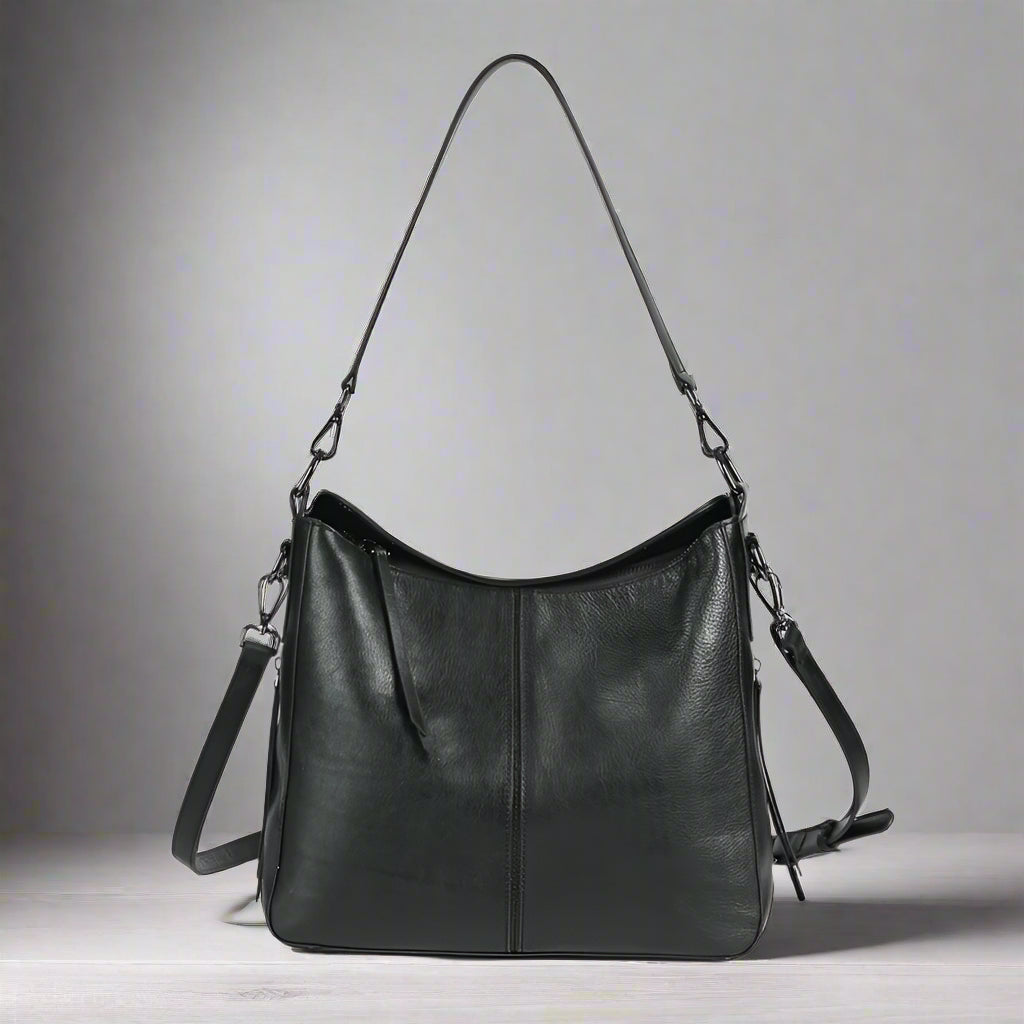 Black leather handbag with shoulder straps on a white background