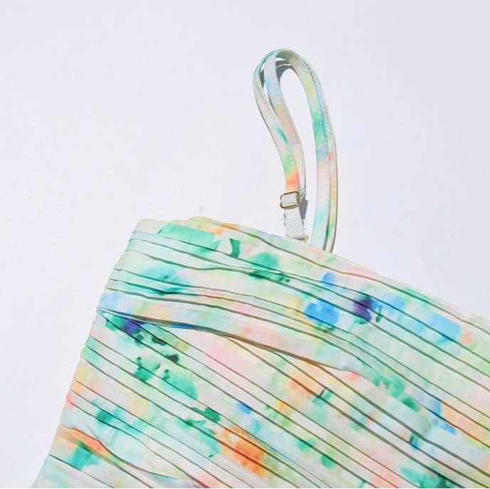 Colorful pleated dress with a strap on a light gray background