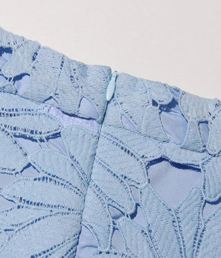 Close-up of textured blue fabric with a subtle pattern on a light gray background