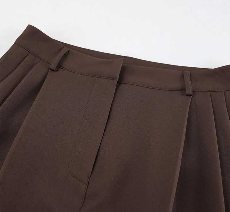 Close-up of brown pleated skirt on a white background