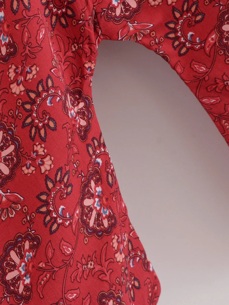 Red fabric with intricate floral patterns on a plain background