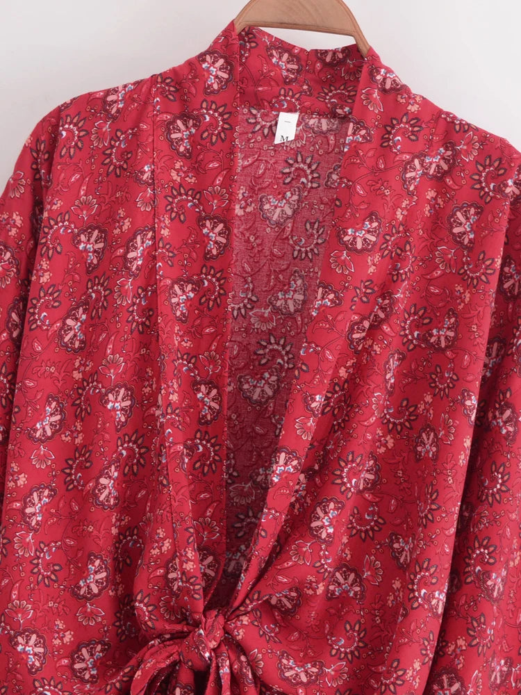 Red floral-patterned shirt on a hanger against a white background