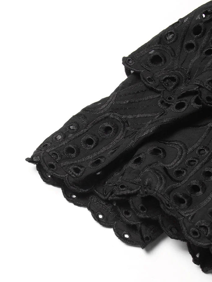 Black lace fabric with intricate patterns on a white background