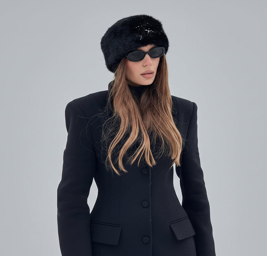 Woman in black coat and hat with sunglasses