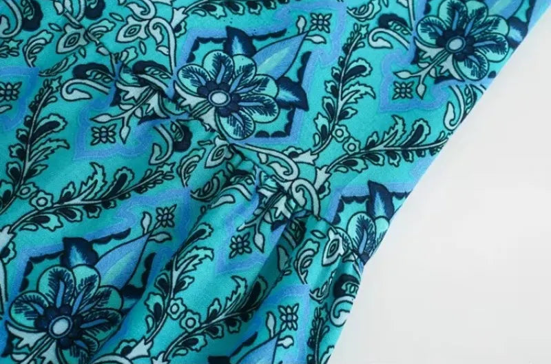 Blue fabric with black floral pattern on a white background