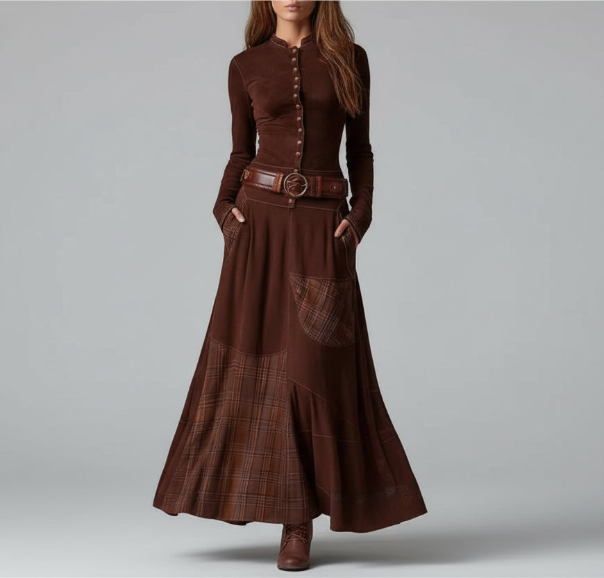 Woman wearing a long brown dress with a belt against a gray background