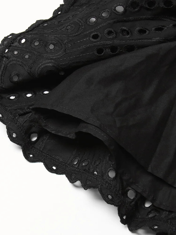 Black fabric with eyelet detailing on a white background