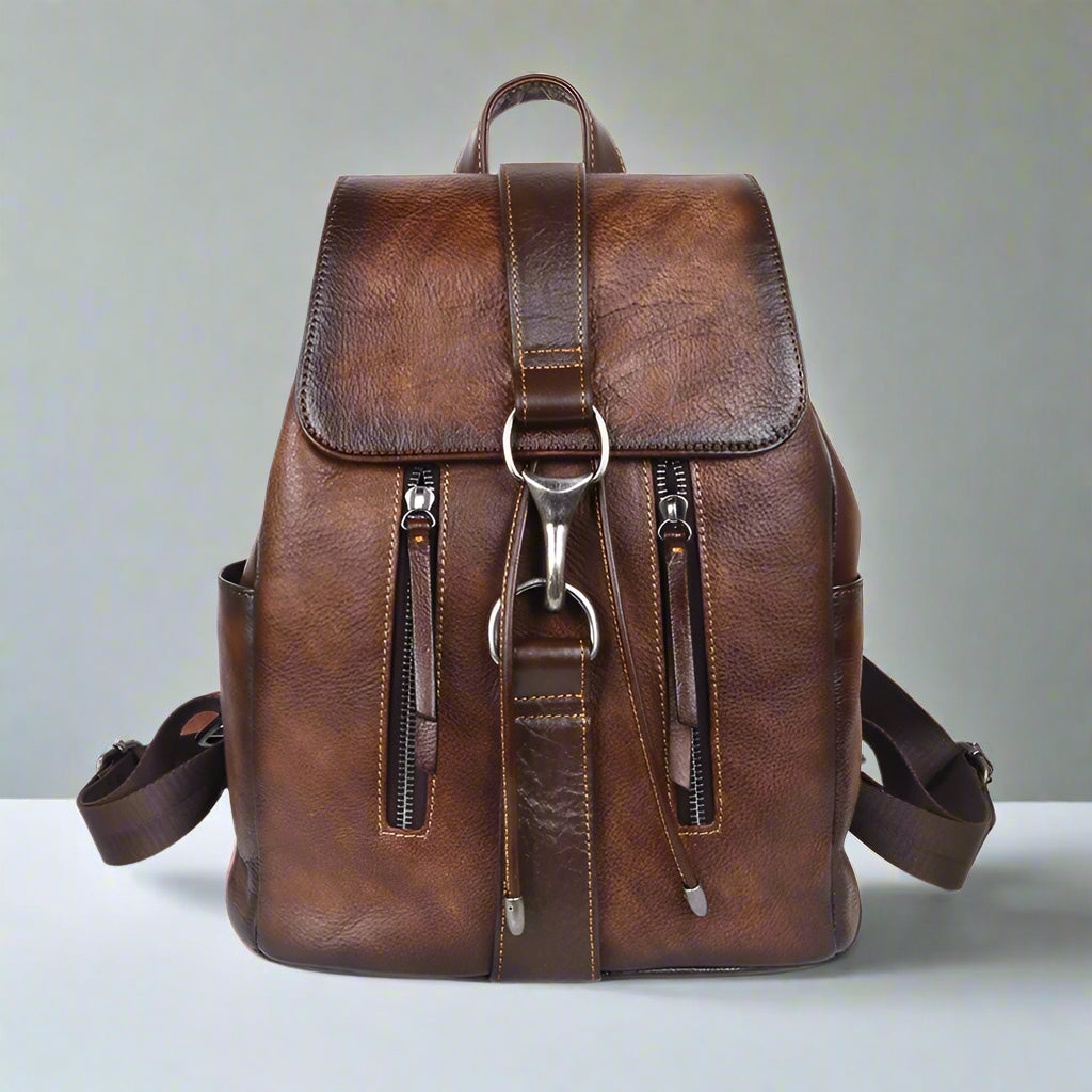 Brown leather backpack with silver zippers on a white background