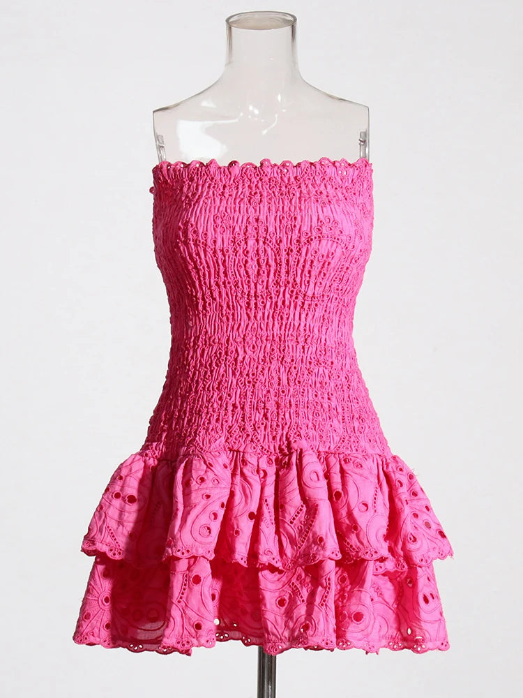 Pink strapless dress with ruffled layers on a mannequin against a white background