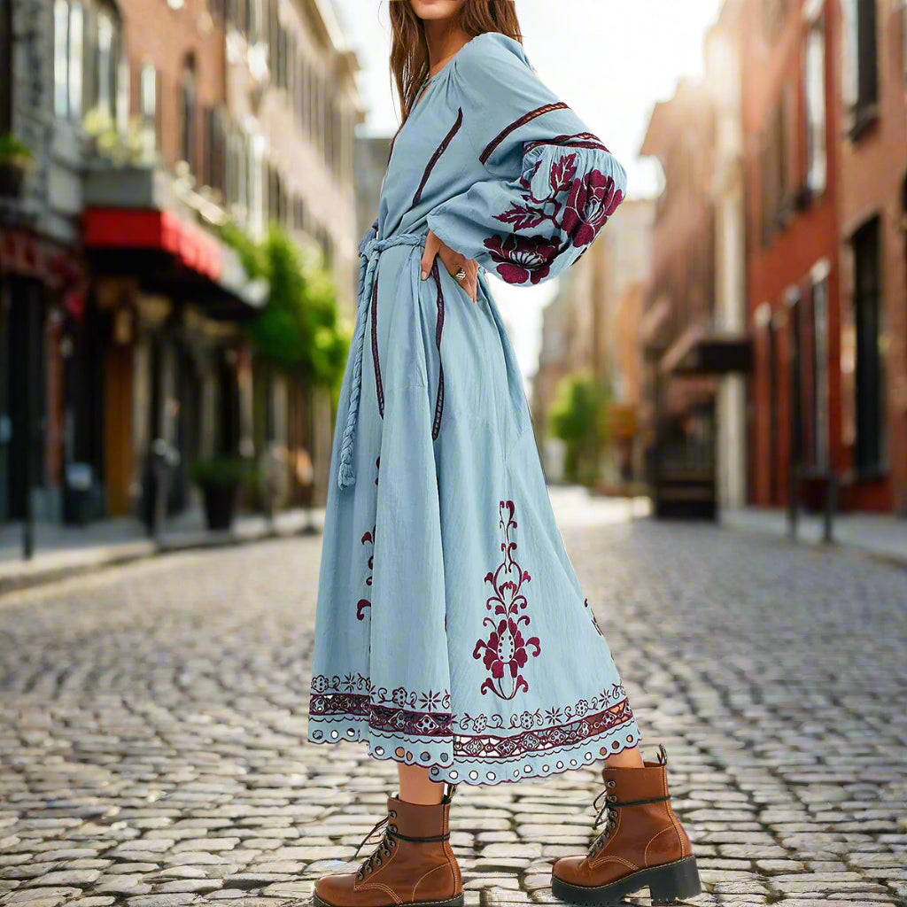Light blue dress with red floral embroidery worn by a person on a backyard