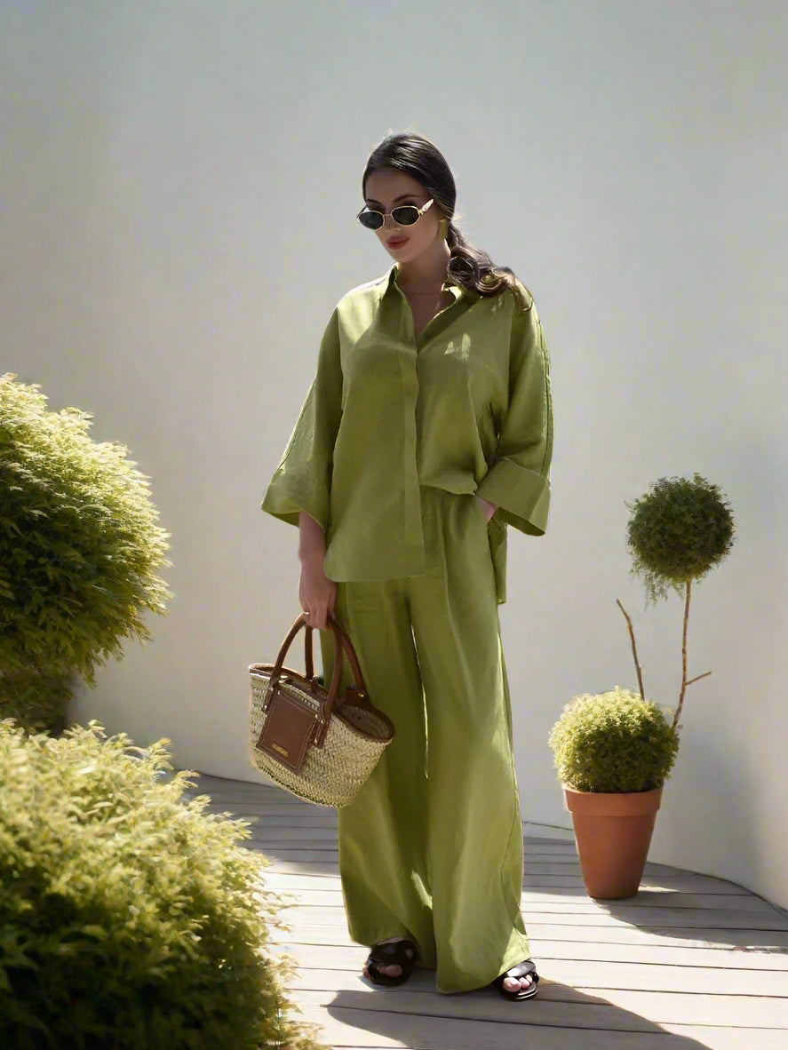 Woman in a green outfit holding a bag with a scenic background,