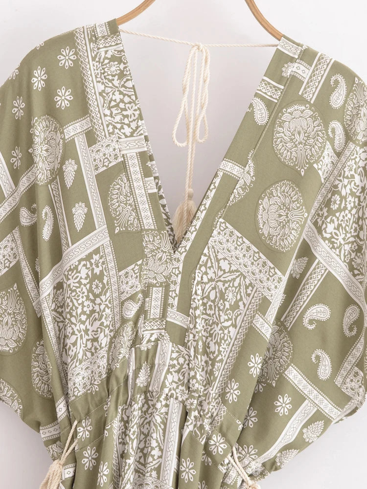 Green and white patterned garment on a hanger against a white background