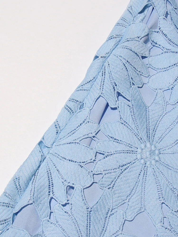 Close-up of light blue fabric with floral pattern on a white background
