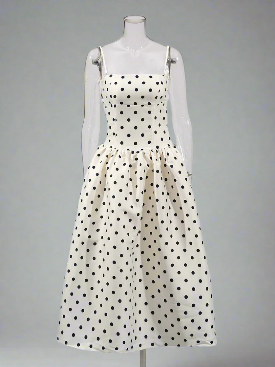 White dress with black polka dots on a mannequin against a white background