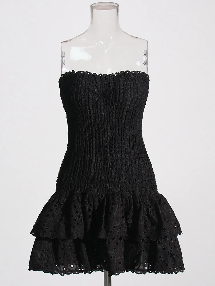 Black strapless dress with ruffled layers on a mannequin against a white background