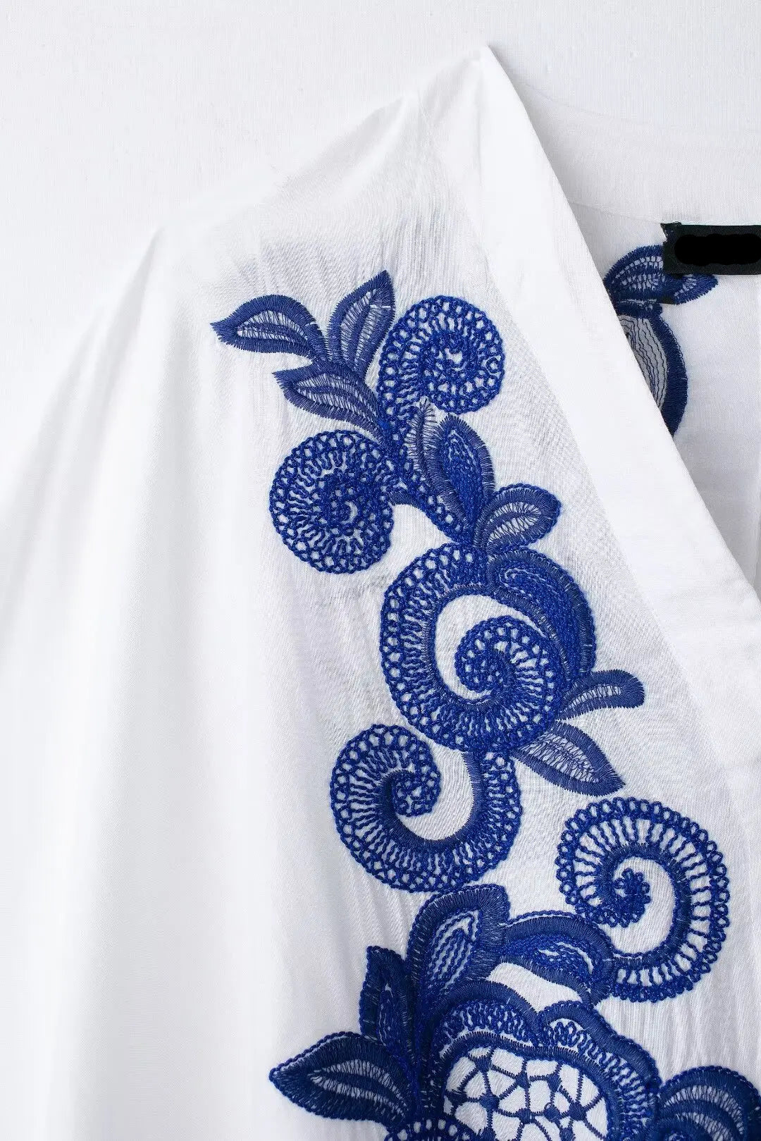 White fabric with blue floral embroidery