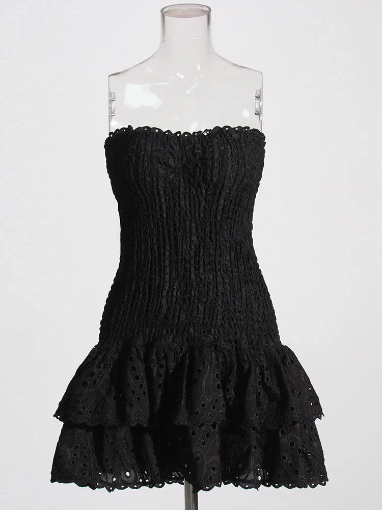 Black strapless dress with ruffled layers on a mannequin against a white background