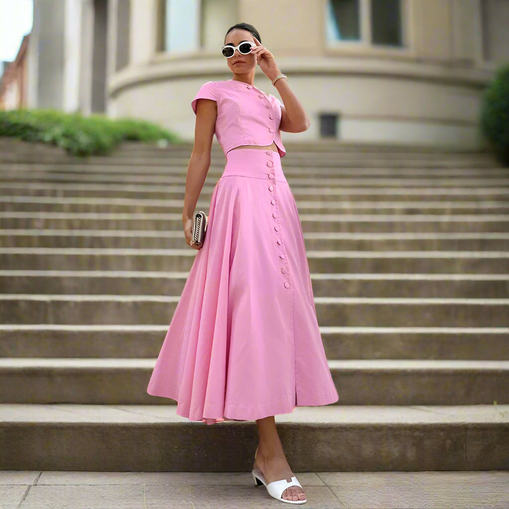 Woman in a pink dress standing on a staircase