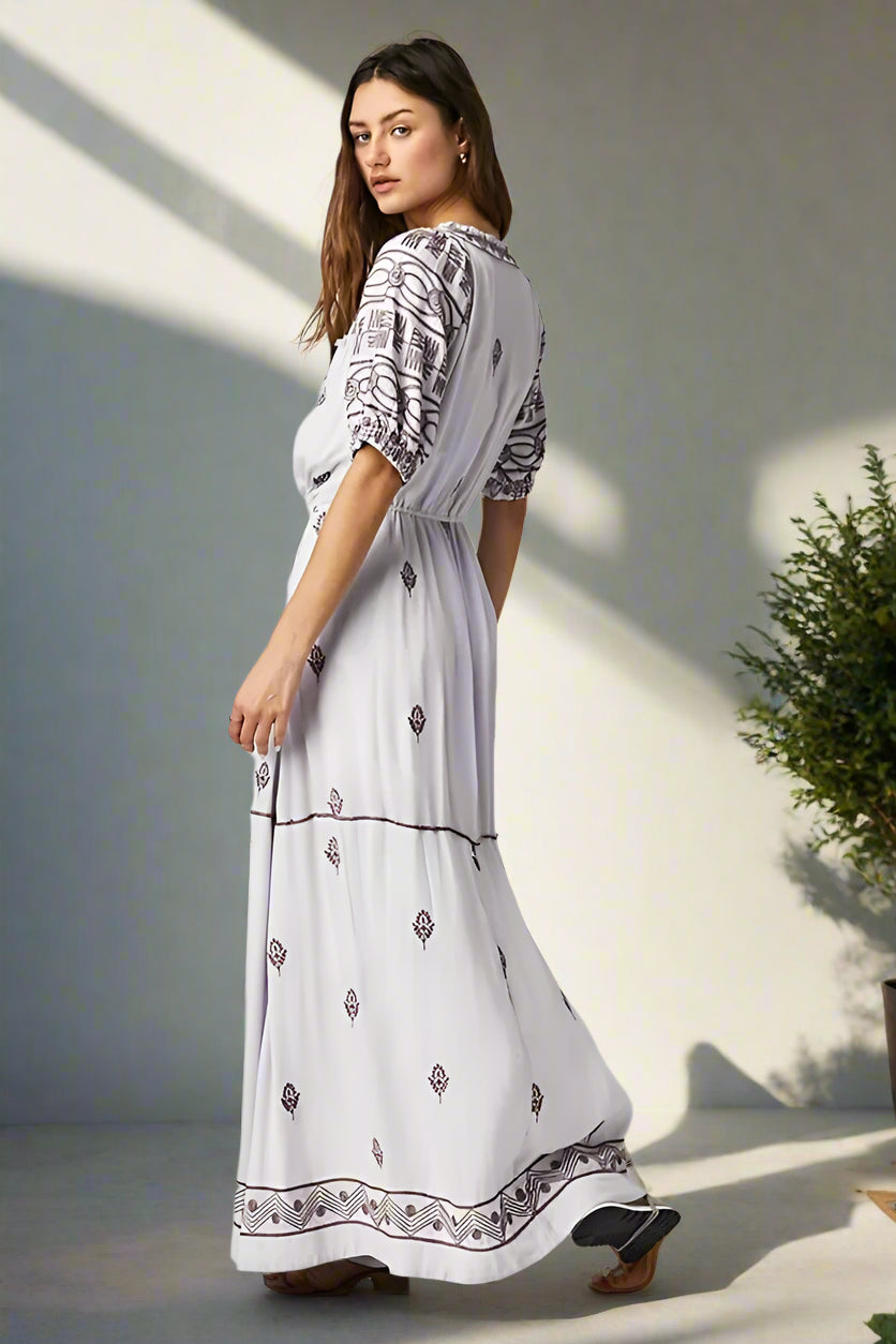 Woman wearing a white dress with black patterns on a white background