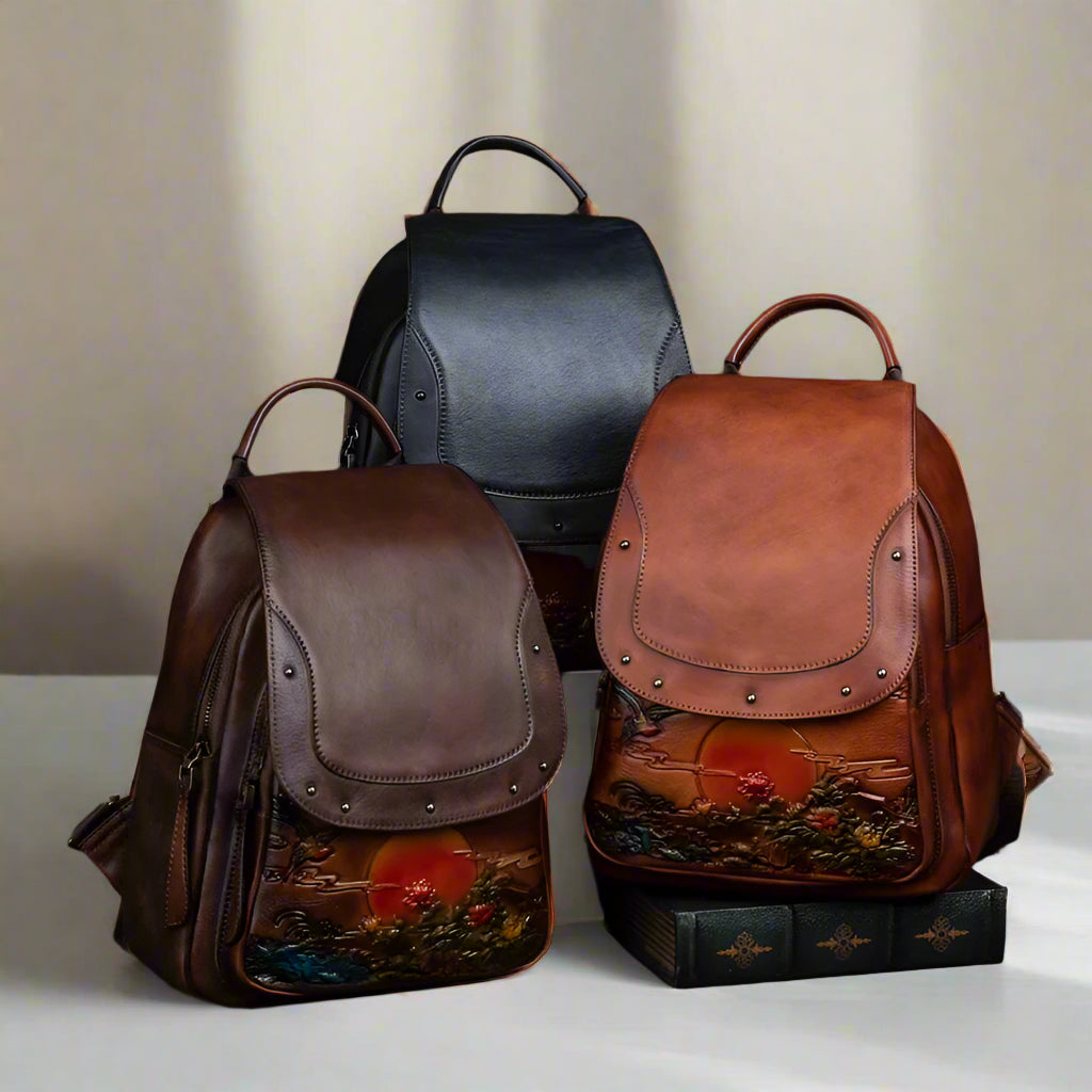 Three leather backpacks with sunset designs on a light background