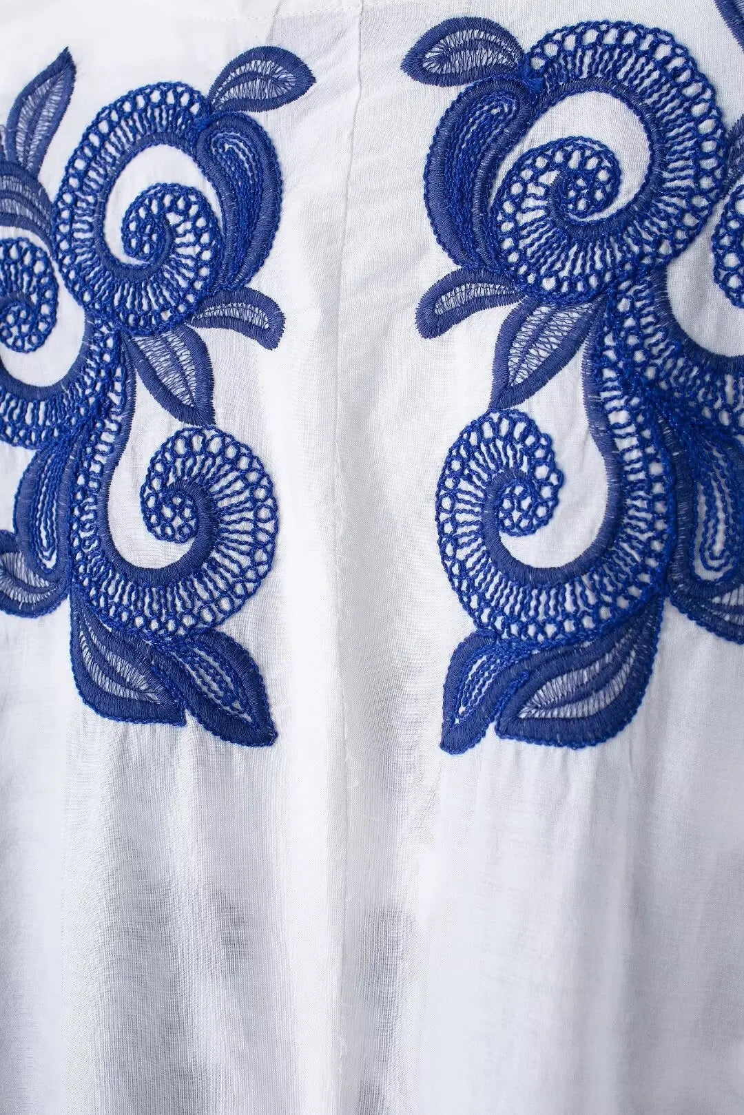 White fabric with blue embroidered floral patterns