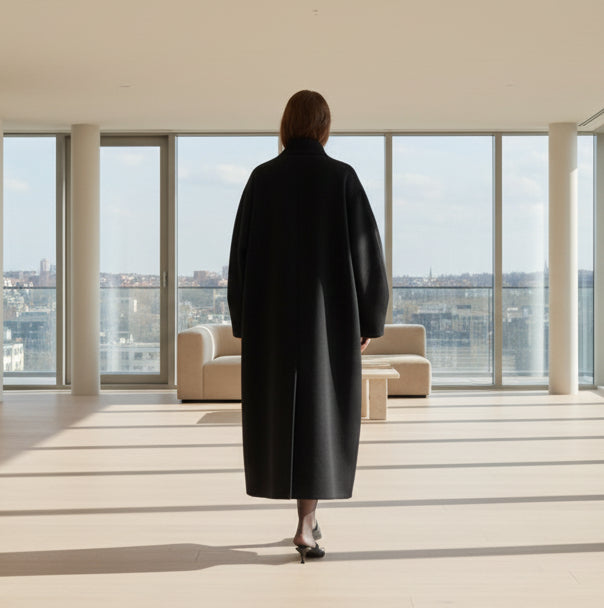 Person wearing a black coat on an empty penthouse