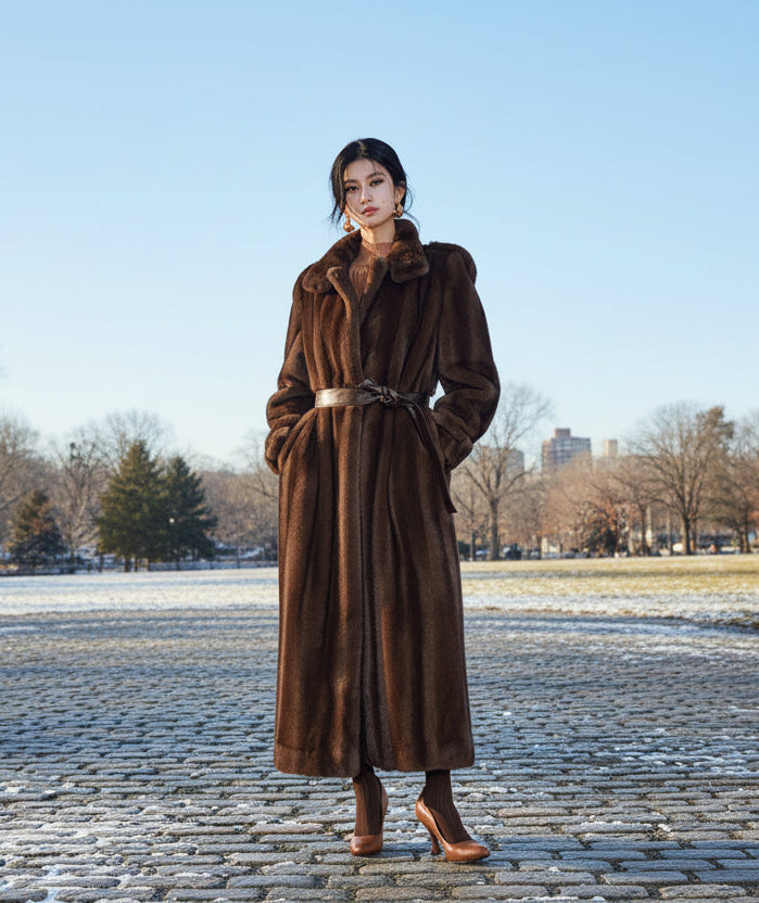 Woman wearing a long brown fur coat in a snowy street