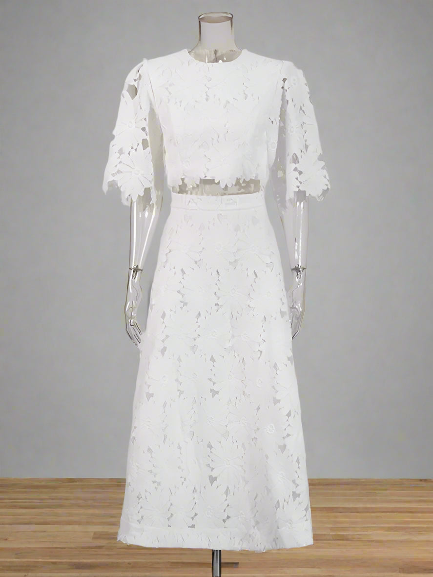 White lace dress on a mannequin against a plain background