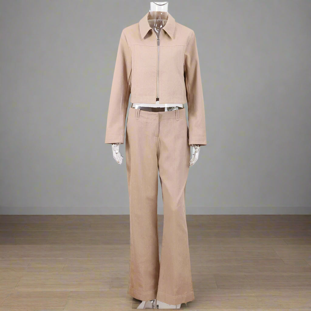 Beige jacket and pants set on a mannequin against a white wall.