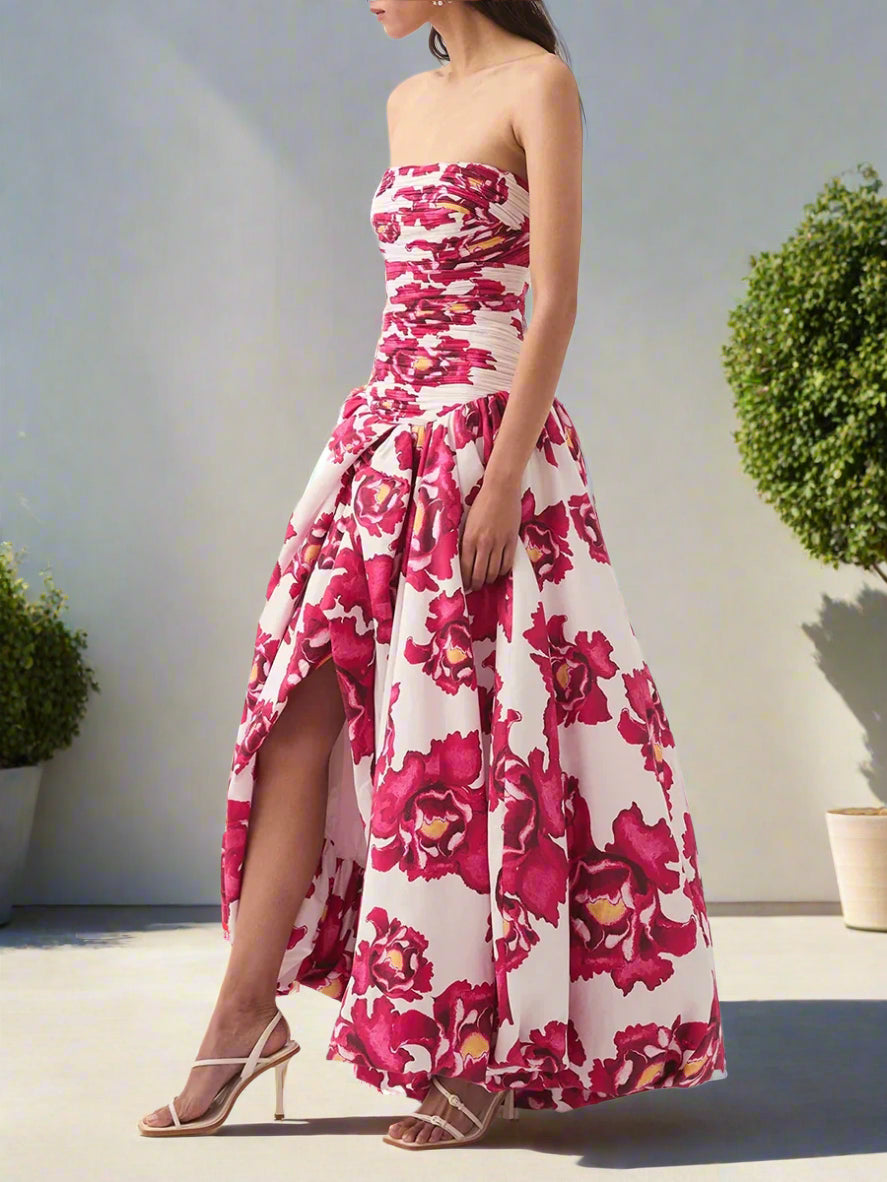 Woman wearing a strapless floral dress with a high slit on a backyard garden, sunny day