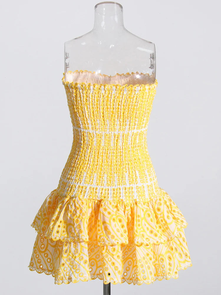 Yellow strapless dress on a mannequin against a white background