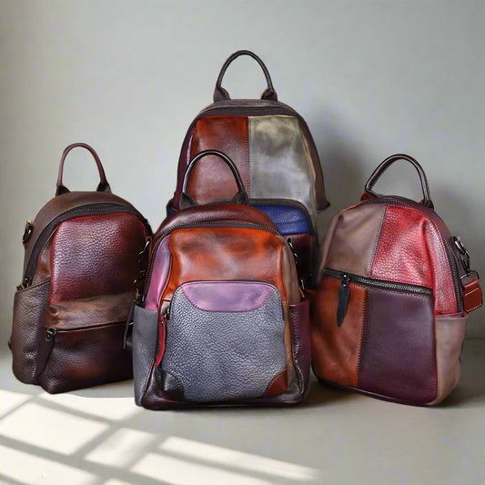 Four patchwork leather backpacks  white wall background.