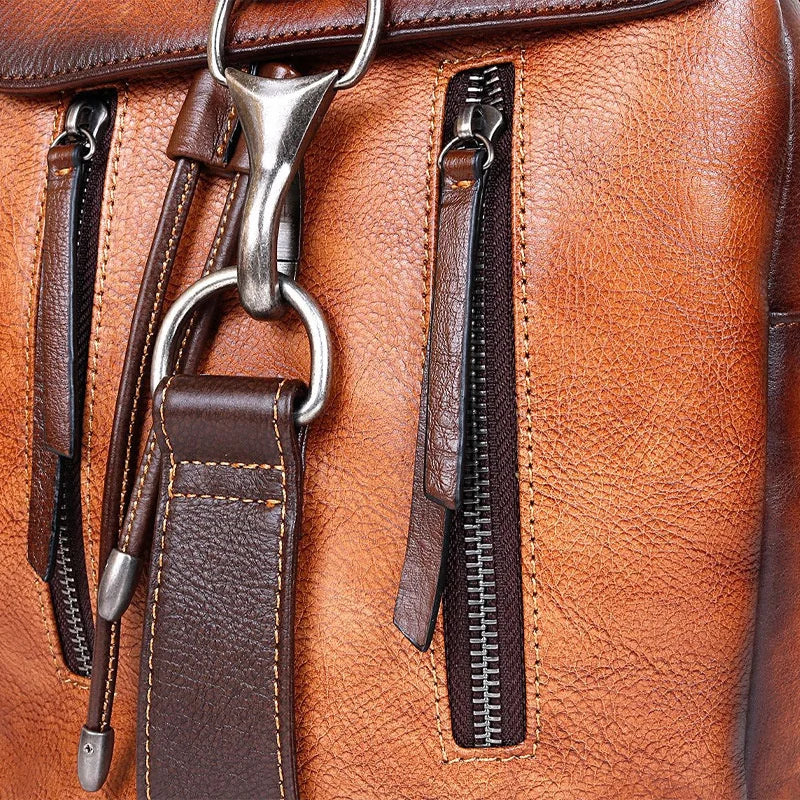 Close-up of a brown leather bag with zippers and straps
