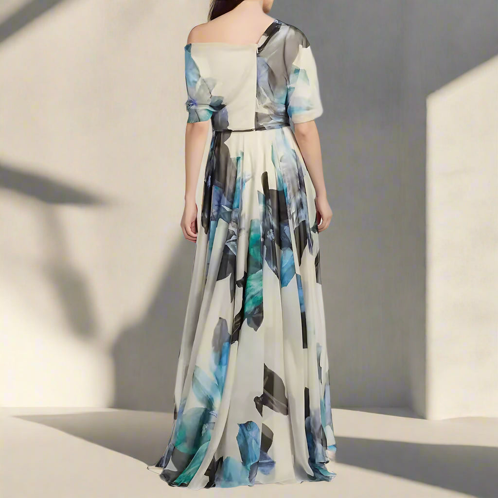 Woman wearing a long, off-shoulder dress with abstract blue and black patterns on a plain background