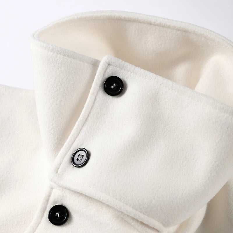 Close-up of a white coat with black buttons on a light gray background