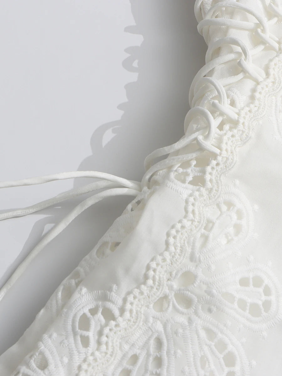 Close-up of a white lace garment on a light gray background