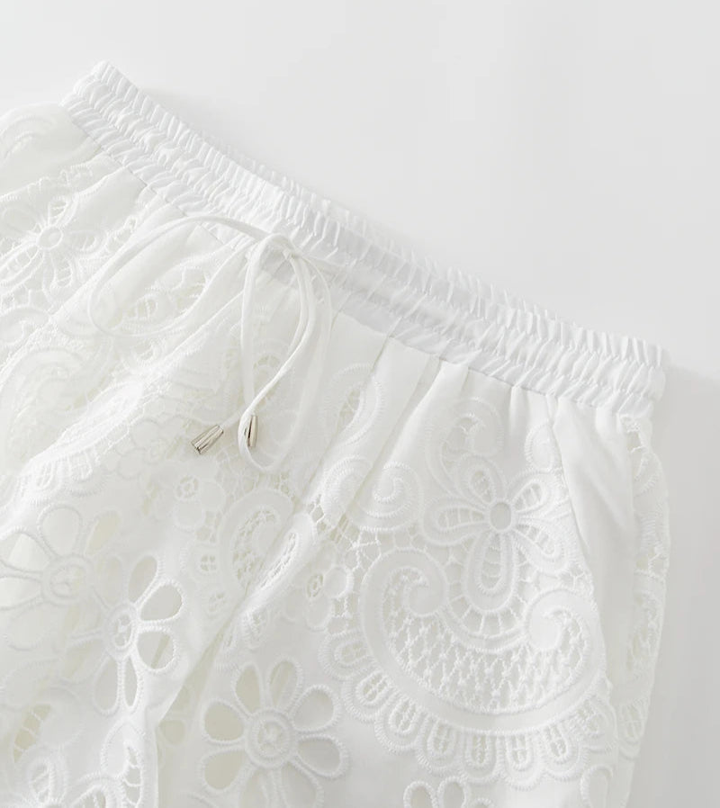White lace pants with a drawstring on a light gray background