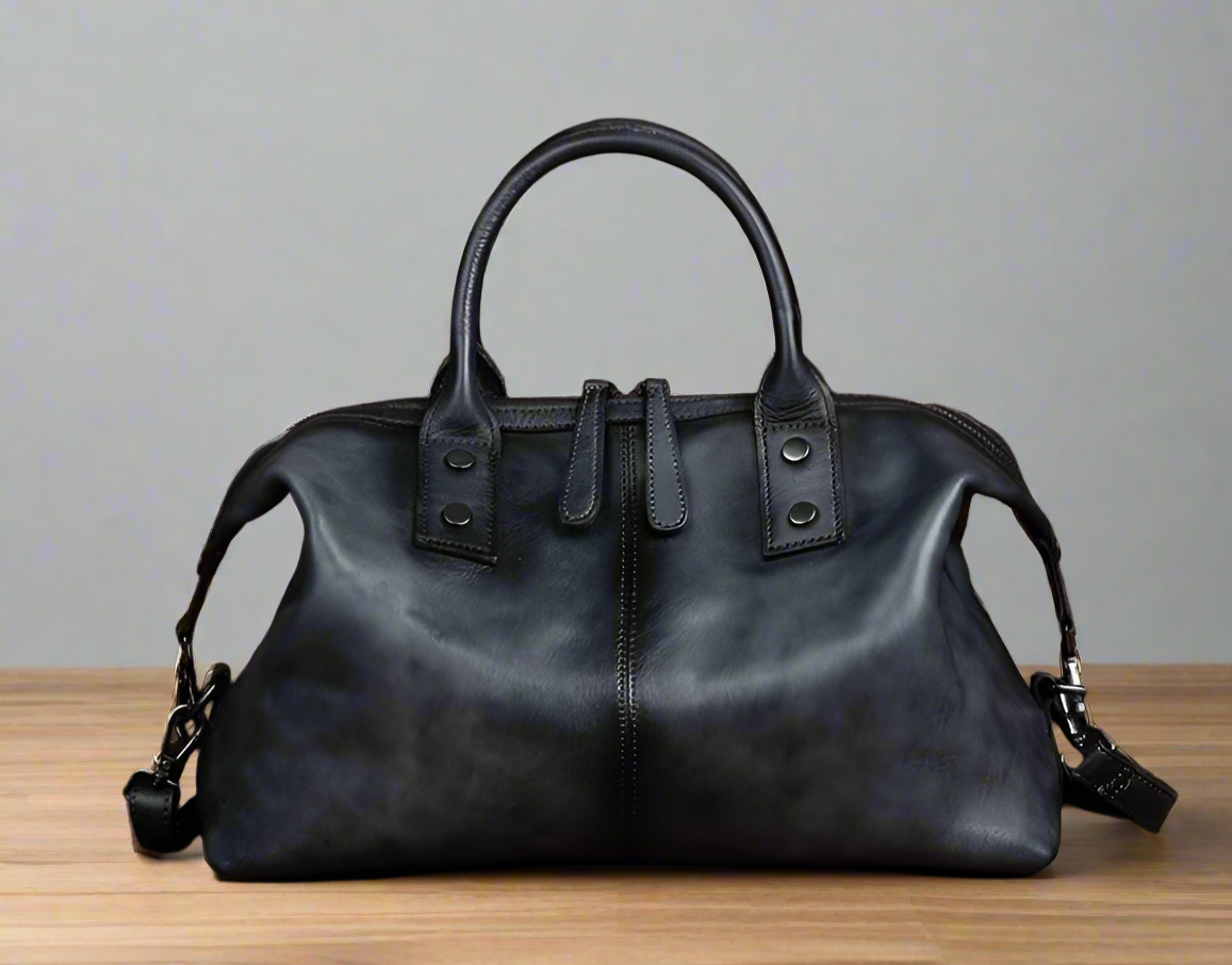 Black leather handbag on a wooden surface with a white background